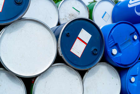 Stack of old chemical barrels. Blue oil drum. Steel and plastic oil tank. Toxic waste warehouse. Hazard chemical barrel. Industrial waste in plastic drum. Hazard waste storage in factory. Empty can.の写真素材