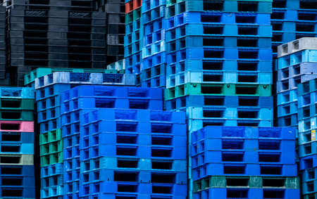 Pile of plastic shipping pallet. Industrial plastic pallet stacked at factory warehouse. Cargo and shipping concept. Plastic pallet rack for export delivery industry. Plastic pallet storage warehouse.の写真素材
