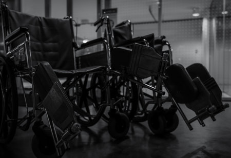 Empty wheelchair in hospital at night for service patient and disabled people. Medical equipment in hospital for assistance handicapped old people. Chair with wheels for patient care in nursing home.の写真素材