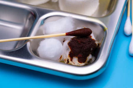 Wound care dressing set and stainless steel plate on blue background. Cotton ball and cotton stick...
