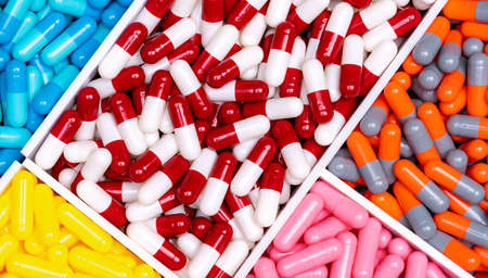 Top view capsule pills in plastic box. Multi colored capsule pills. Vitamin and supplement concept. Pharmaceutical industry. Pharmacy products. Healthcare and medicine. Pharmaceutical manufacturing.の写真素材