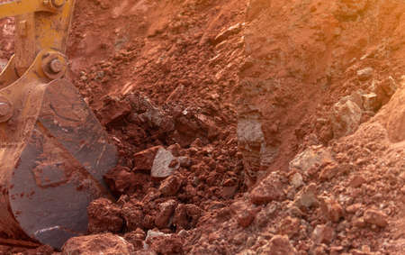 Backhoe working by digging soil at construction site. Bucket of backhoe digging soil. Crawler...