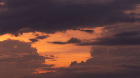 Beautiful orange sunset sky with layers of gray and dark clouds. Scenic view. Beauty in nature....