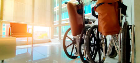Empty wheelchair in private hospital for service patient and disabled people. Medical equipment in hospital for assistance handicapped old people. Chair with wheels for patient care in nursing home.の写真素材