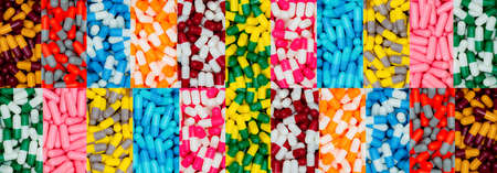 Top view of multi-color capsule pills. Pharmaceutical industry. Many antibiotics, painkillers, supplements capsule pills. Capsule pill production. Pharmacy banner. Drug selection. Pharmacy products.の写真素材