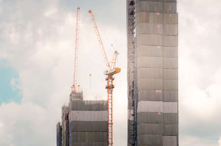 Skyscraper building construction. Crane working in construction site. Property and real estate development industry. Apartment building construction. Background for REIT fund. Building for rent.の写真素材