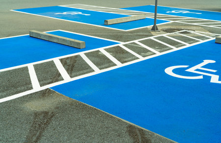 Asphalt car parking lot reserved for handicapped driver in supermarket or shopping mall. Car parking space for disabled people. Wheelchair sign paint on asphalt parking area. Handicapped parking lot.の写真素材