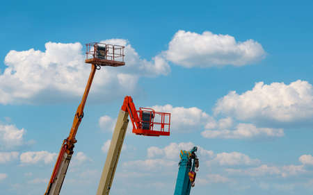 Articulated boom lift. Aerial platform lift. Telescopic boom lift against blue sky. Mobile...