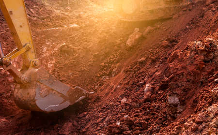 Metal bucket of backhoe digging soil. Backhoe working by digging soil at the construction site....