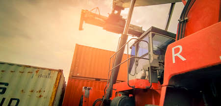 Reach stacker lifting container. Forklift truck handling container at dock. Reach stacker vehicle....