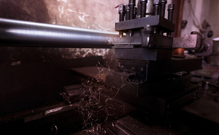 Lathe machine working in factory. Lathe turning machine for metalwork. Heavy machinery manufacturing. Machine for milling metal. Manual lathe machine. Safety in industrial workplace. Steel industry.の写真素材