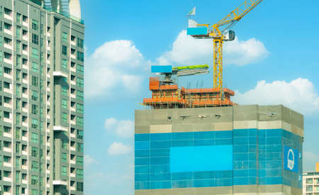 Construction site with crane and skyscraper building. Real estate industry. Crane in construction...