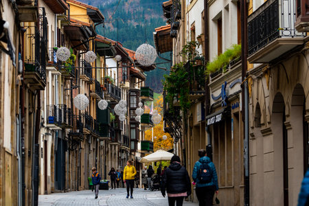 ONATI, SPAIN-DECEMBER 8, 2021 : People walking on the street between old building in Spain. Travel in Spain. Town near the mountain. Europe travel concept. Onati city, Spain. Tourism in Europe.のeditorial素材