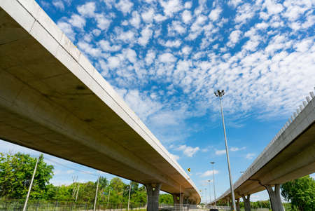 Bottom view of elevated concrete highway. Overpass concrete road. Strong structure of cement bridge. Concrete bridge engineering construction. Bridge architecture. Infrastructure budget policy conceptの写真素材