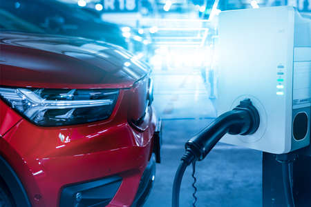 Car charging at electric car charging station. Electric vehicle charger station for charge EV battery. Charging point at car parking lot. Clean and sustainable energy. Commercial EV charging point.の写真素材
