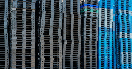 Pile of plastic shipping pallet. Industrial plastic pallet stacked at factory warehouse. Cargo and shipping concept. Plastic pallet rack for export delivery industry. Plastic pallet storage warehouse.の写真素材