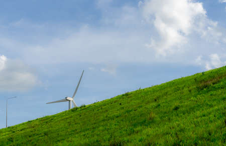 Wind energy. Wind power. Sustainable, renewable energy. Wind turbines generate electricity. Windmill farm on a mountain with blue sky. Green technology. Renewable resource. Sustainable development.の写真素材