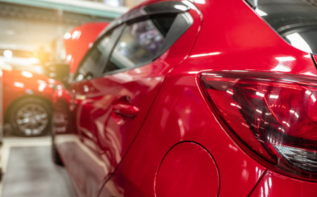 Rear view of red SUV car parked in car repair shop. Red car in workshop of service station. Vehicle...