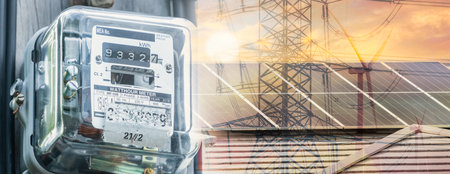 Watt hour meter on rooftop solar, wind turbine, and electric pylon background. Sustainable energy. Solar and wind power. Renewable energy. Energy crisis. Carbon neutrality. Sustainable resources.の写真素材