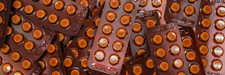 Small round tablets pills in brown blister pack. Prescription drugs. Pharmaceutical industry....