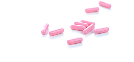 Pink capsule pills on white background. Pharmaceutical industry. Vitamins, minerals, and supplements concept. Pharmacy products. Pharmaceutical medicine. Prescription drugs. Healthcare and medicine.の写真素材