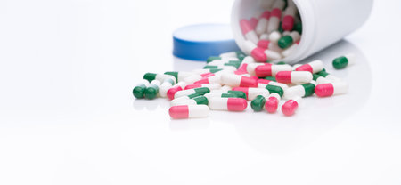 Antibiotic capsule pills spread out of plastic bottle. Pharmaceutical industry. Antibiotic drug...