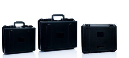 New toolbox or plastic case isolated on white background. Empty hard plastic suitcase with handle. Set of black plastic travel luggage. Modern case for toolkit, drone storage. Black new tool box.の写真素材