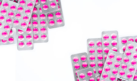Pink tablet pills in blister pack isolated on white background. Painkiller medicine. Pharmaceutical industry. Prescription drugs. Ibuprofen for treatment pain. Pharmacy product. Medical health care.の写真素材