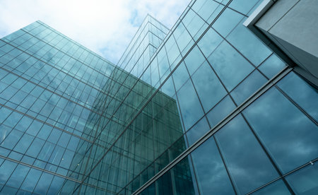 Modern sustainable glass office building. Exterior view of corporate headquarters glass building architecture. Energy-efficient building. Financial business center tower. Glass windows of company.の写真素材