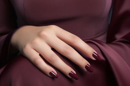 Woman hand with burgundy color nail polish on her fingernails. Burgundy nail manicure with gel polish at luxury beauty salon. Nail art and design. Female hand model. French manicure. Generative AI.の素材