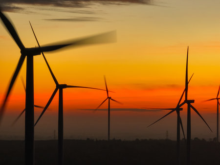 Wind farm landscape against sunset sky. Wind energy. Wind power. Sustainable and renewable energy. Wind turbines generate electricity. Green technology. Renewable resources. Sustainable development.の写真素材