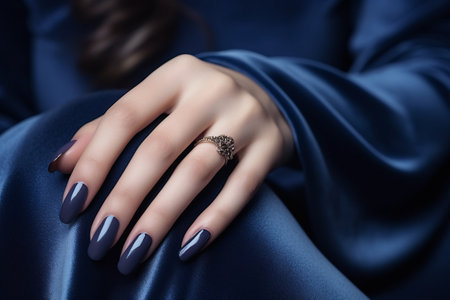Glamour woman hand with navy blue nail polish on her fingernails. Navy nail manicure with gel polish at luxury beauty salon. Nail art and design. Female hand model. French manicure. Generative AI.の素材