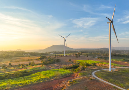Wind farm field and sunset sky. Wind power. Sustainable, renewable energy. Wind turbines generate electricity. Sustainable development. Green technology for energy sustainability. Eco-friendly energy.の写真素材