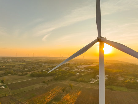 Wind farm field and sunset sky. Wind power. Sustainable, renewable energy. Wind turbines generate electricity. Sustainable development. Green technology for energy sustainability. Eco-friendly energy.の写真素材