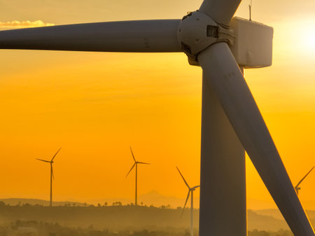 Wind farm field and sunset sky. Wind power. Sustainable, renewable energy. Wind turbines generate electricity. Sustainable development. Green technology for energy sustainability. Eco-friendly energy.の写真素材
