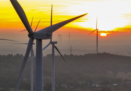 Wind farm field and sunset sky. Wind power. Sustainable, renewable energy. Wind turbines generate electricity. Sustainable development. Green technology for energy sustainability. Eco-friendly energy.の写真素材