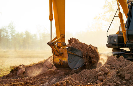 Backhoe working by digging soil at construction site. Crawler excavator digging on demolition site. Excavating machine. Earth moving machine. Excavation vehicle. Construction business.の写真素材