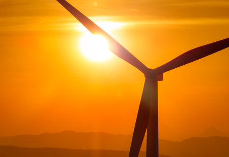 Wind farm field and sunset sky. Wind power. Sustainable, renewable energy. Wind turbines generate electricity. Sustainable development. Green technology for energy sustainability. Eco-friendly energy.の写真素材