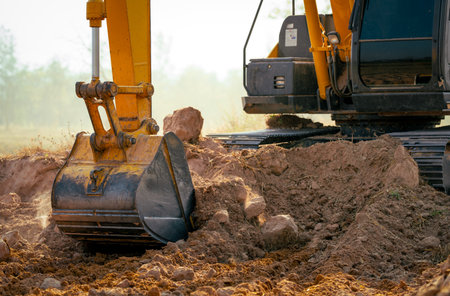 Closeup bucket of backhoe digging the soil at construction site. Crawler excavator digging on demolition site. Excavating machine. Earth moving equipment. Excavation vehicle. Construction business.の写真素材