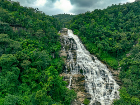 Aerial view of a waterfall in a lush tropical green forest in Doi Inthanon National Park, Chiang Mai, Thailand. This nature landscape showcases water sustainability and scenic travel destinations.の写真素材