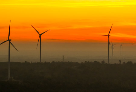 Wind farm field and sunset sky. Wind power. Sustainable, renewable energy. Wind turbines generate electricity. Sustainable development. Green technology for energy sustainability. Eco-friendly energy.の写真素材