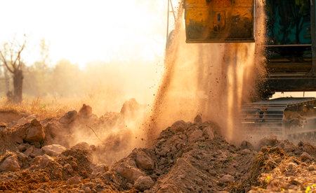 Backhoe working by digging soil at construction site. Crawler excavator digging on demolition site. Excavating machine. Earth moving machine. Excavation vehicle. Construction business.の写真素材