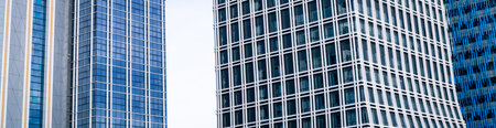 Skyscraper glass building of corporate headquarters in the downtown business area. Towering facade and windows embodying sleek, modern office environment. Financial institution. Modern architecture.の写真素材