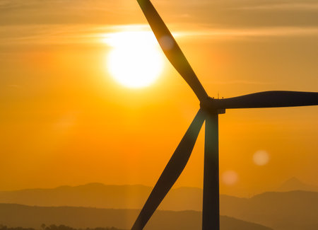 Wind farm field and sunset sky. Wind power. Sustainable, renewable energy. Wind turbines generate electricity. Sustainable development. Green technology for energy sustainability. Eco-friendly energy.の写真素材