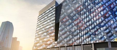Modern headquarters of electric and hybrid car manufacturer. Glass office building reflecting rows of new vehicles. Corporate architecture for sustainable automotive industry. Eco-friendly car companyの写真素材