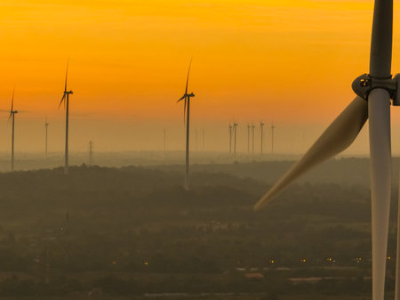 Wind farm field and sunset sky. Wind power. Sustainable, renewable energy. Wind turbines generate electricity. Sustainable development. Green technology for energy sustainability. Eco-friendly energy.の写真素材