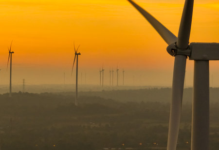Wind farm field and sunset sky. Wind power. Sustainable, renewable energy. Wind turbines generate electricity. Sustainable development. Green technology for energy sustainability. Eco-friendly energy.の写真素材