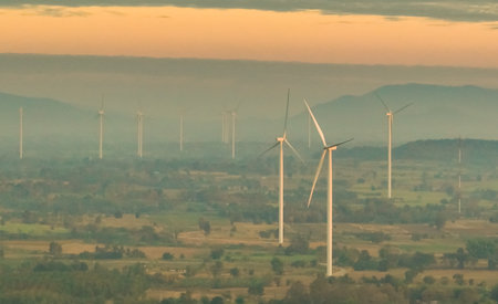 Wind farm field and sunset sky. Wind power. Sustainable, renewable energy. Wind turbines generate electricity. Sustainable development. Green technology for energy sustainability. Eco-friendly energy.の写真素材