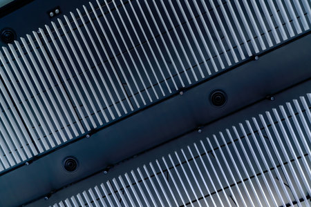 Looking up view of commercial HVAC air handling units mounted on ceiling in modern car showroom providing efficient climate control and ventilation for automotive retail businesses and customers.の写真素材