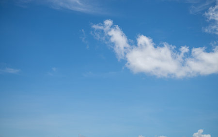 Beautiful blue sky with white cumulus clouds on sunny summer day. Peaceful natural background perfect for wellness marketing and environmental awareness campaigns. Relaxation and meditation backgroundの写真素材